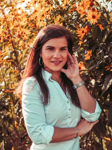 Portrét ženy v bílé košili u rozkvetlých květin